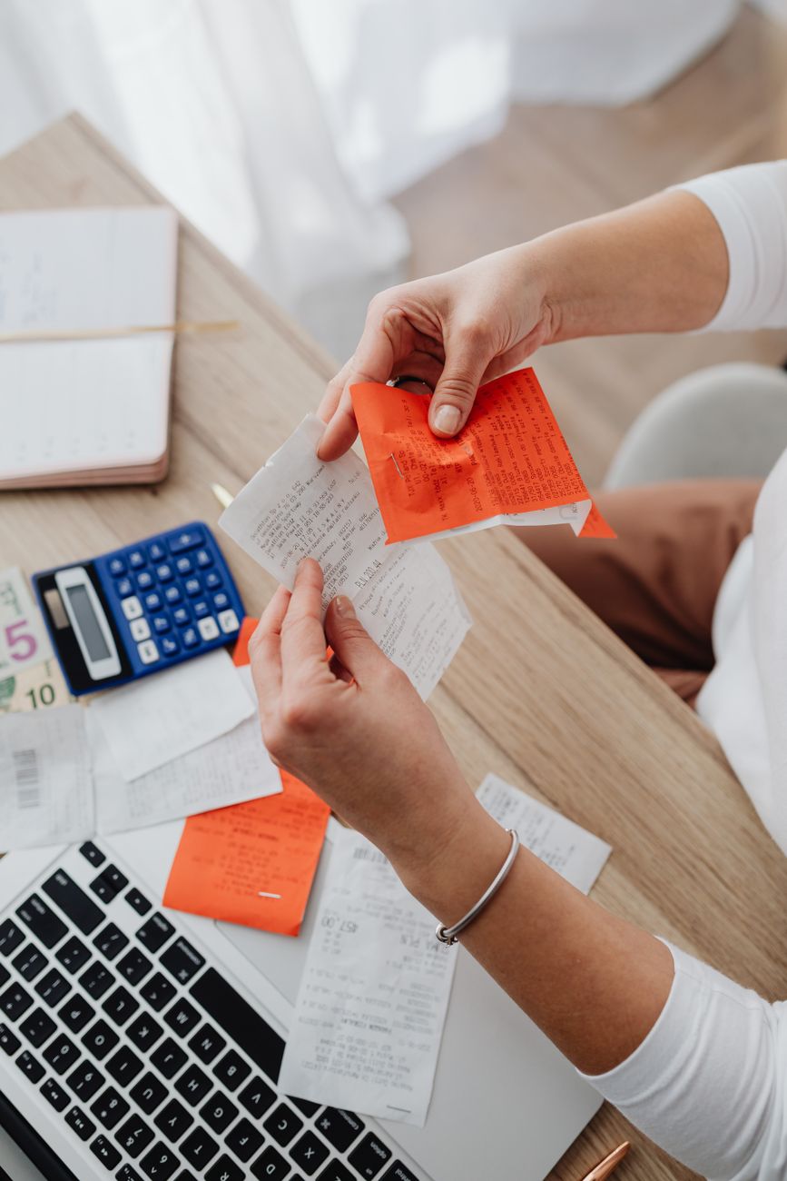 A sole trader organising receipts and financial records at a desk